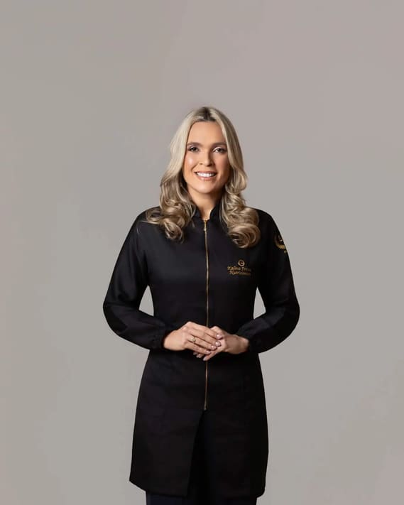 Retrato da nutricionista Kalina Freitas, de jaleco preto com bordado dourado